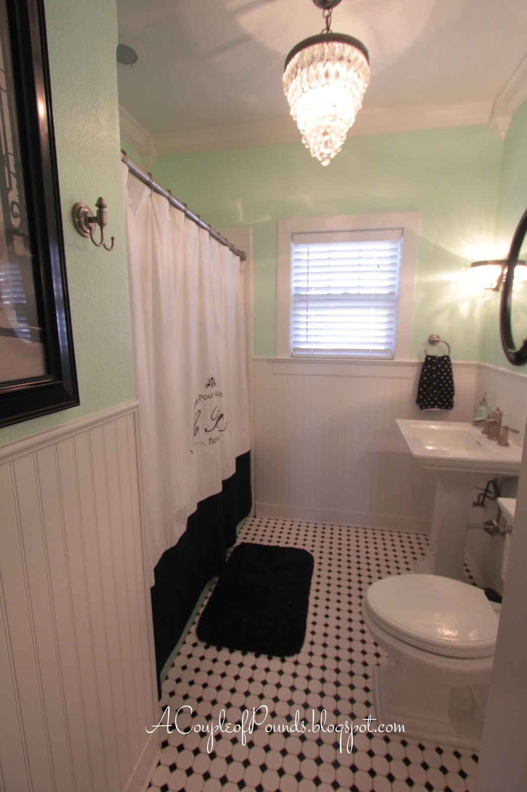 Updated Vintage Bathroom with chandelier and black and white classic tile